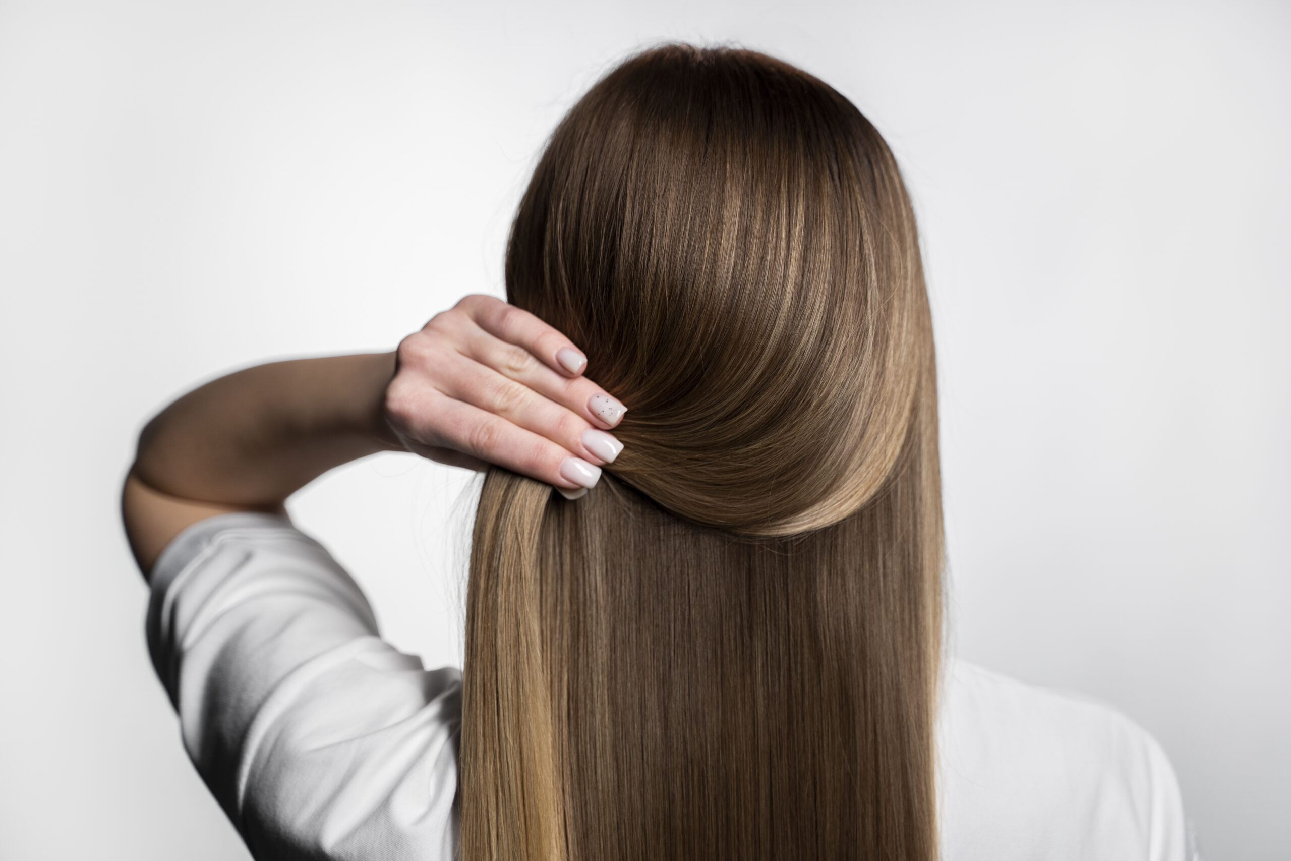 consejos para cuidar tu cuero cabelludo. vista de la parte de atras del cabello muy brillante de una mujer