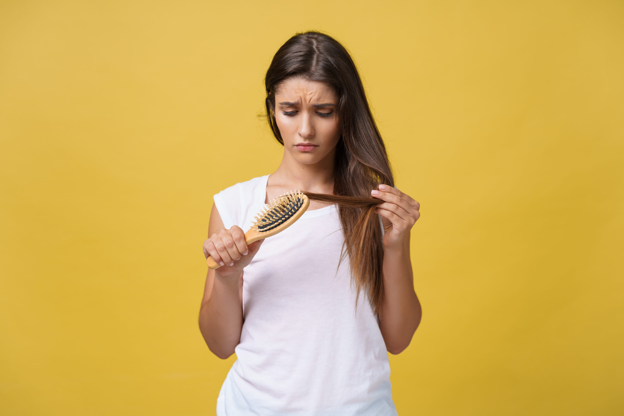 ¿Cuánto Pelo se Cae al Día? mano de mujer sosteniendo su cabello caido